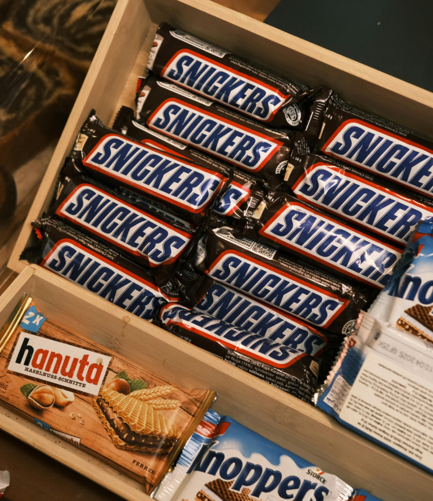 Holzkiste voller Schokoriegel und Süßigkeiten wie Snickers, Hanuta und Knoppers im Mato Kiosk Wetzlar