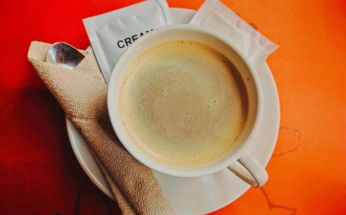 Eine frische Tasse Kaffee mit Milch und Zucker auf einem Tisch im Mato Kiosk Wetzlar